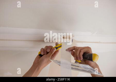 man plastering ceiling repair. Selective focus. Stock Photo