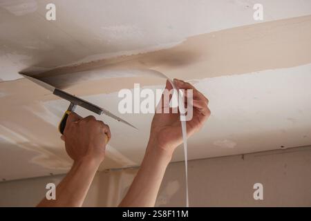 man plastering ceiling repair. Selective focus. Stock Photo