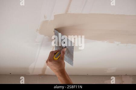 man plastering ceiling repair. Selective focus. Stock Photo