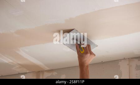 man plastering ceiling repair. Selective focus. Stock Photo