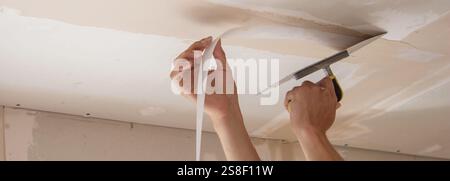man plastering ceiling repair. Selective focus. Stock Photo