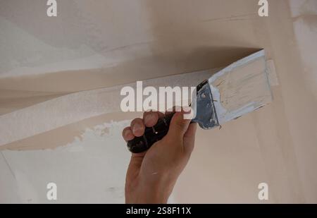 man plastering ceiling repair. Selective focus. Stock Photo