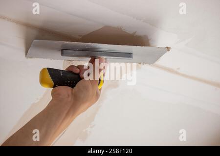 man plastering ceiling repair. Selective focus. Stock Photo