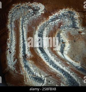 Close-up of a natural stone exhibiting distinctive layered patterns and textures in earthy shades of brown and gray, ideal for artistic applications Stock Photo
