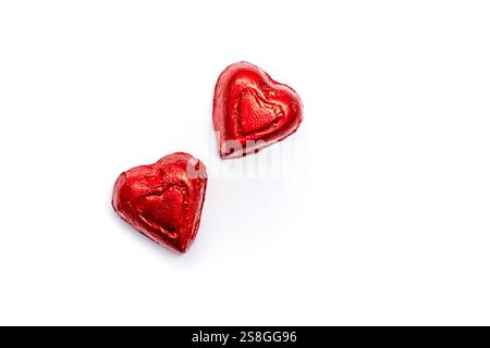 Two vibrant red heart-shaped candies rest on a clean white background, ideal for romantic occasions Stock Photo
