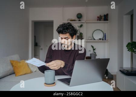 Young stressed looking handsome middle eastern man using computer and being overwhelmed by work. Stock Photo