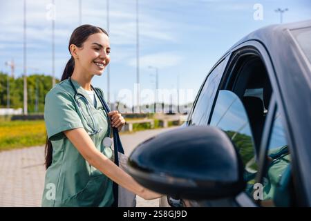 Smiling young woman in lab coat standing at the car Stock Photo