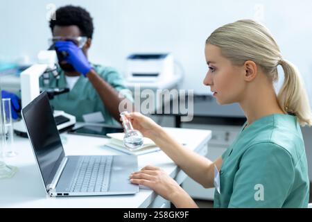Medical woman and man working together in office using computer and microscope Stock Photo