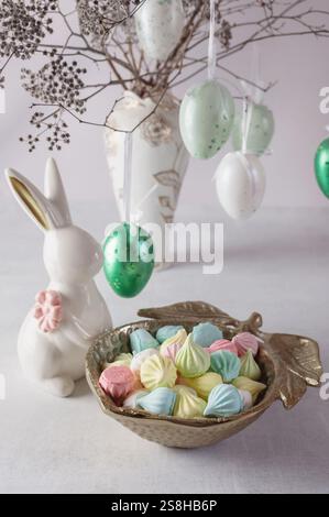 Easter decorations with eggs, colorful meringue and Easter decorations on a wooden table. Stock Photo