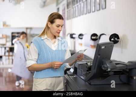 Technician operator calibrating plotter machine, typing on computer keyboard Stock Photo