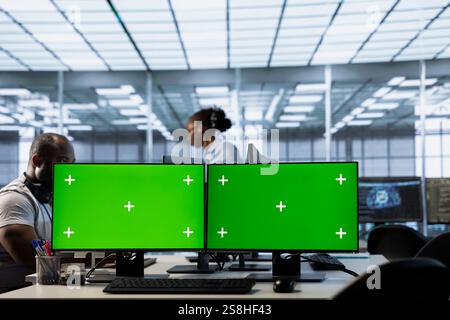Multi monitor isolated screen computer setup used by engineers working in server hub processing data. Mockup PC displays used by employees to update servers controlling network resources Stock Photo