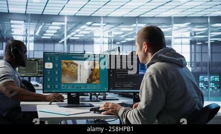 Engineer in server hub making generative artificial intelligence website generating videos using diffusion model algorithms. Employee coding AI virtual assistant producing clips, camera B Stock Photo