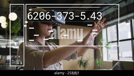Image of financial data processing over asian businesswoman using vr headset in office Stock Photo