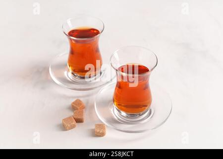 Glasses of Turkish tea with sugar cubes on white background Stock Photo
