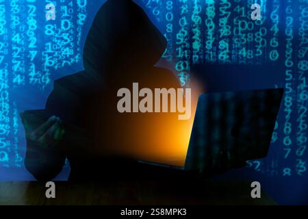 Computer hacker stealing data from a laptop Stock Photo