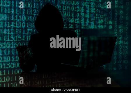 Computer hacker stealing data from a laptop Stock Photo