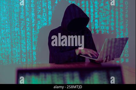 Hacker holding and using laptop over binary code digital background. Hacking the Internet. Selective focus. Stock Photo