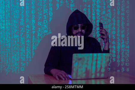A hacker uses a malware with mobile phone and laptop to hack password the personal data and money from Bank accounts. The concept of cyber crime Stock Photo