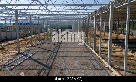 A large industrial warehouse under construction with steel beams and columns. Stock Photo