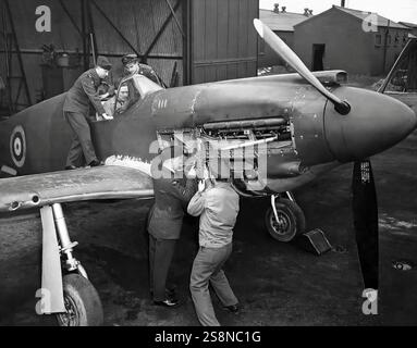 Fitters at RAF Burtonwood Airfield in the north of England, working on a North American Aviation P-51 Mustang, long-range, single-seat fighter and fighter-bomber used during World War II. Designed in 1940 the  aircraft was flown very successfully by the RAF as a tactical-reconnaissance aircraft and fighter-bomber. In mid 1942, the Allison engine was replaced with a Rolls-Royce Merlin 65 two-stage inter-cooled supercharged engine that dramatically improved the aircraft's performance at altitudes above 15,000 ft without sacrificing range. Stock Photo