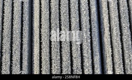 Close up of ice crystals on the slats of a wooden structure. Backdrop with vertical slats. Stock Photo