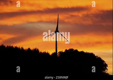 Wind turbine in the foreground in front of a dramatic orange-coloured sky at sunset, renewable energy, Upper Palatinate Stock Photo