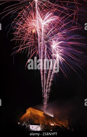 Red and blue firework rockets rise into the air and light up the dark night, New Year's Eve, Stallbastei, Schlossberg, Graz, Styria Stock Photo