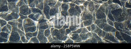 An image of a pebble water caustics background with color refractions Stock Photo