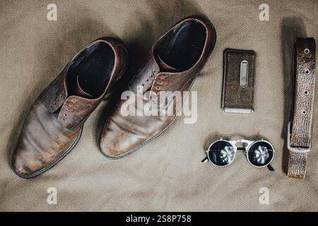 Vintage leather shoes with stylish accessories on an earthy textured surface Stock Photo