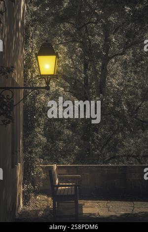 An image of a lonely bench under a lamp by night Stock Photo
