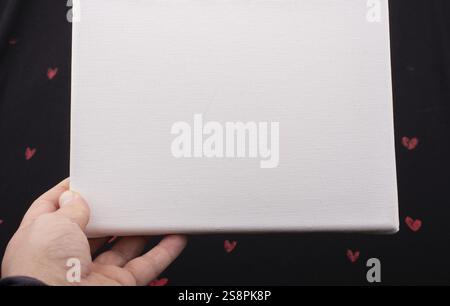 White blank canvas on black background with red hearts Stock Photo