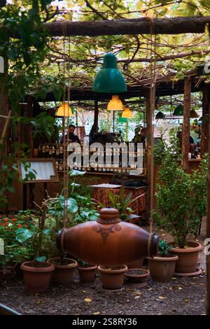 large clay bottle of wine hangs on ropes Stock Photo