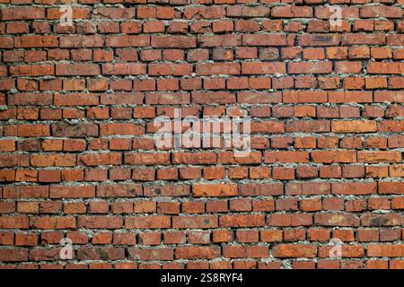 Red brick wall with detailed texture and visible mortar between bricks Stock Photo