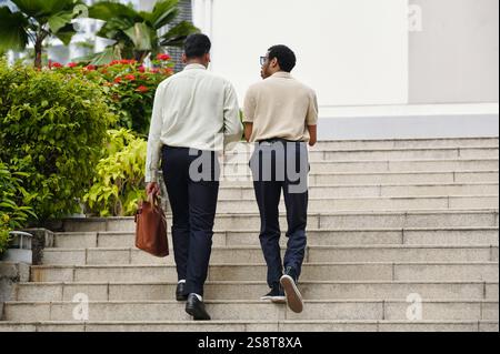 Rear view of two businessmen walking up the stairs in the city Stock Photo