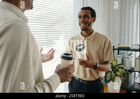 Colleagues having meeting during coffee break in office, they talking and drinking coffee Stock Photo