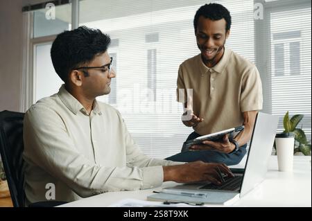 Businessman using tablet pc and working with his colleague over online project in office Stock Photo