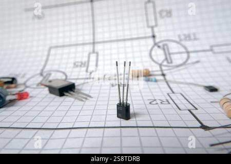 Electronic components standing on circuit diagram with transistor and resistor. Foscused on transistor. Stock Photo