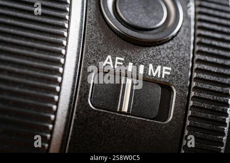 Close up of the auto or mannual focus button on the new camera lens. Af and mf switch on the camera lens, controls of a mirrorless camera, macro Stock Photo