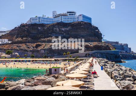 Luxury hotel Riu Vista Mar perched on rocky cliffs above Atlantic Ocean with scenic promenade leading along breakwater. Gran Canaria, Las Palmas, Spai Stock Photo
