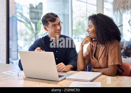 Happy busy coworkers working together on laptop computer at office meeting. Stock Photo