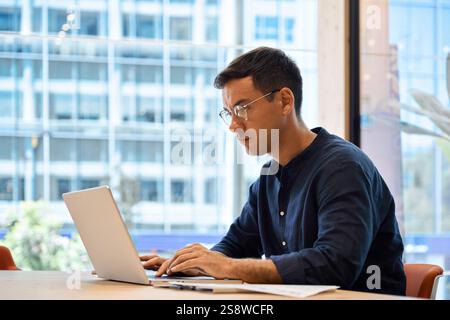 Busy professional business man using laptop working sitting at office desk. Stock Photo