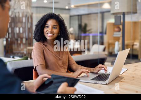 African American female bank manager consulting male client at meeting. Stock Photo