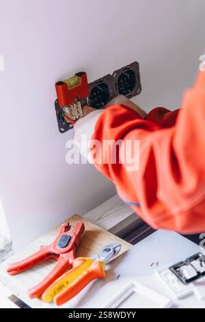 repair, renovation, electricity and electrician hands with screwdriver fixing socket. High quality photo Stock Photo