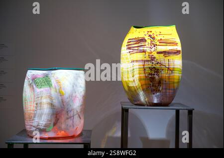 Two colorful glass sculptures by Dale Chihuly displayed on black pedestals, showcasing his expressive glass artistry and bold color patterns Stock Photo