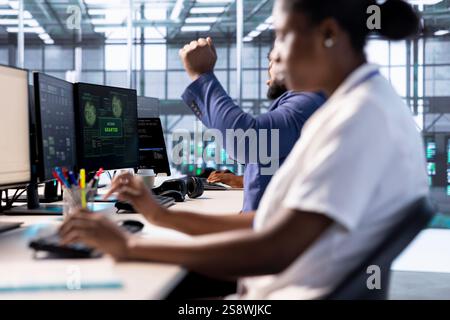 Admin in server farm celebrating after getting access granted, managing to access files after they were locked by hacker using ransomware, receiving aid from IT experts, doing hand gesture Stock Photo