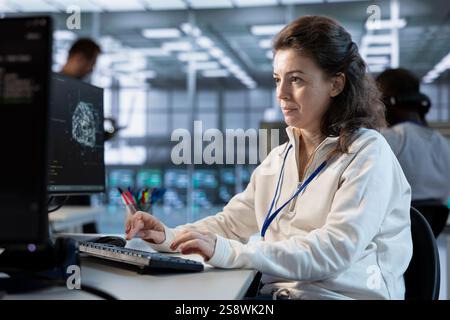 Technician using computer to do maintenance on artificial intelligence neural networks. System administrator using AI system aiding in processing and transmitting information Stock Photo