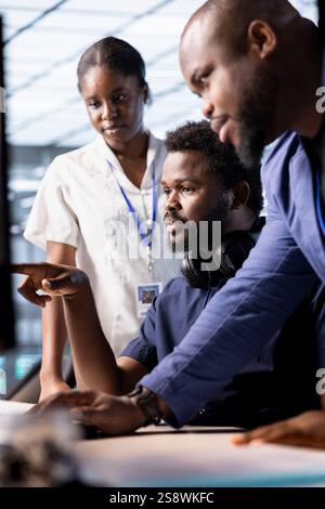 Team of cybersecurity experts monitoring security incidents affecting server hub network, working together. Engineering coworkers doing brainstorming in data center protecting company from threats Stock Photo