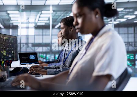 Computer scientists in data center using diagnostic tools and system monitoring software to identify errors. Team of IT specialists in server farm establishment repairing equipment Stock Photo