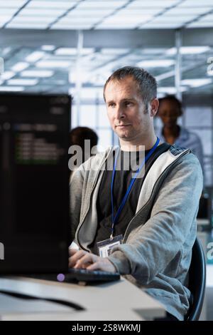IT professional optimizing data center gear for maximum efficiency and uptime. Software developer in server hub maintaining optimal network performance, performing backups Stock Photo