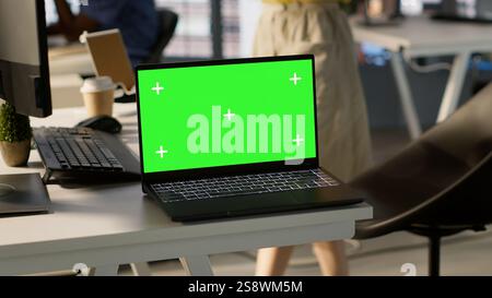 Focus on chroma key laptop in workspace used by computer scientists doing software debugging. Close up of isolated screen notebook used by workers in office fixing coding issues, camera A Stock Photo